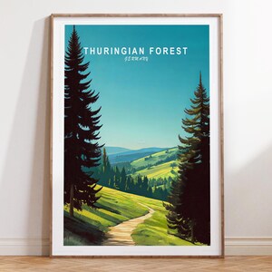 May include: A framed print featuring a scenic view of the Thuringian Forest in Germany. The artwork depicts a winding path through green hills and a forest, under a blue sky. The text "THURINGIAN FOREST GERMANY" is at the top.