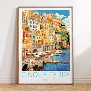 May include: A colourful illustration of the Cinque Terre region of Italy, featuring a hillside town with colourful buildings, a blue sea, and boats. The text "Cinque Terre" and "Italy" is printed below the image.