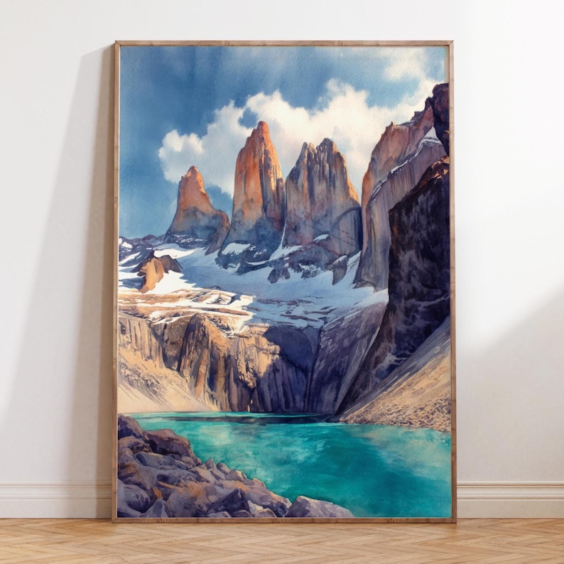 K&ouml;nnte beinhalten: Aquarellmalerei einer Berglandschaft mit schneebedeckten Gipfeln und einem t&uuml;rkisfarbenen See. Das Kunstwerk ist in einem Holzrahmen gerahmt. Der Himmel ist blau mit wei&szlig;en Wolken, und die Berge haben einen goldenen Farbton.