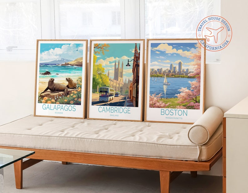 K&ouml;nnte beinhalten: Drei Vintage-Reiseposter mit Holzrahmen. Die Poster zeigen Bilder von Galapagos, Cambridge und Boston. Die Poster werden auf einem hellbraunen Sofa mit einem wei&szlig;en Kissen ausgestellt.