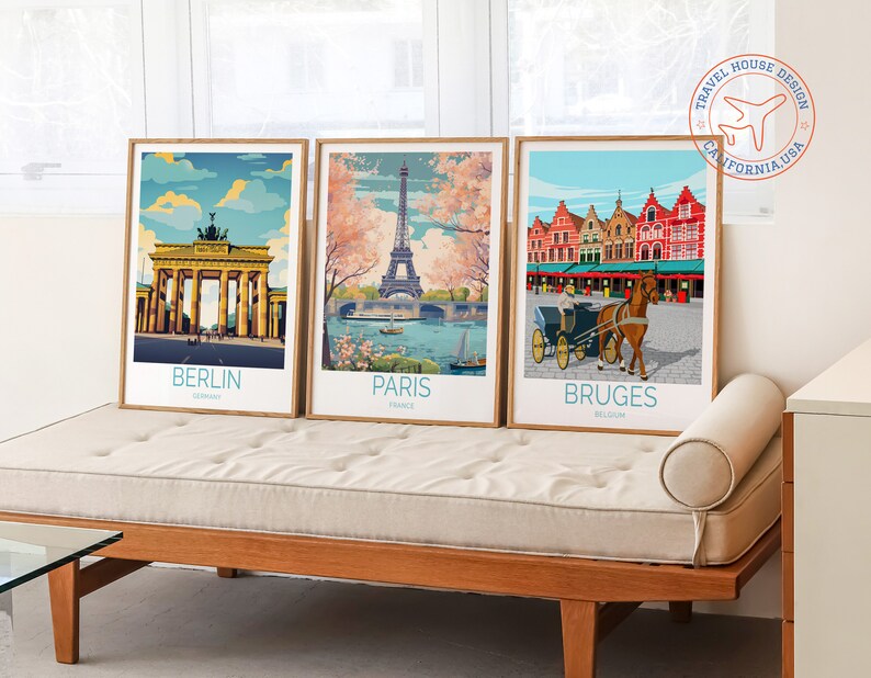 May include: Three framed travel posters with vintage-style illustrations of iconic landmarks. The posters feature the Brandenburg Gate in Berlin, the Eiffel Tower in Paris, and the Markt in Bruges. Each poster has the city name and country printed below the image.