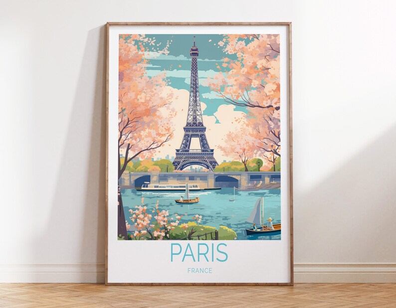 May include: A vintage-style poster featuring the Eiffel Tower in Paris, France. The tower is depicted in black against a blue sky with white clouds. Pink cherry blossoms frame the tower on either side. The poster has a blue and white title that reads "PARIS, FRANCE".