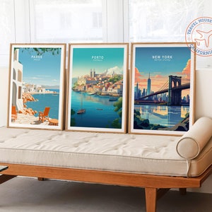 May include: Three framed travel posters with illustrations of cities. The posters are on a light brown couch with a white cushion. The posters are titled "Paros Greece", "Porto Portugal", and "New York Brooklyn Bridge".