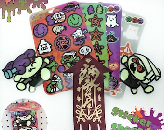 Könnte beinhalten: Ein 'Splatoween' Stickerbogen-Pack mit vier Bögen, zwei davon leuchtend im Dunkeln, und einem exklusiven Band. Die Aufkleber zeigen Cartoon-Charaktere und Halloween-Designs in Orange, Grün, Lila und Weiß.