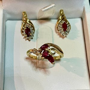 以下が含まれることがあります： ルビーとダイヤモンドのデザインの金の指輪と、それに合わせたルビーとダイヤモンドのイヤリングのペア