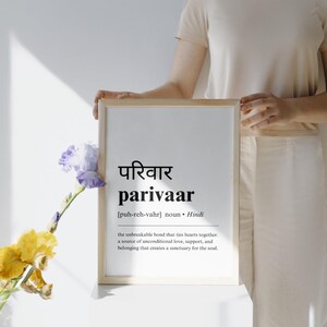 May include: A framed print with the Hindi word "परिवार" (parivaar) and its English translation, "the unbreakable bond that ties hearts together. A source of unconditional love, support, and belonging that creates a sanctuary for the soul."