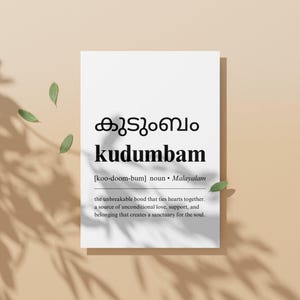 May include: A black and white printable art print with the Malayalam word for family, "kudumbam", written in large font. The word is defined as "the unbreakable bond that ties hearts together. A source of unconditional love, support, and belonging that creates a sanctuary for the soul."