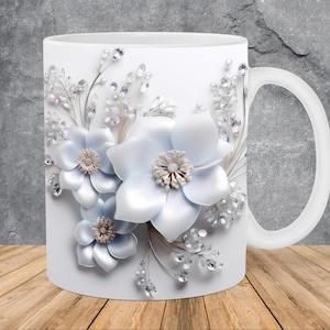 May include: White ceramic mug with a floral design. The flowers are white with a pearl-like sheen and are surrounded by silver glitter.