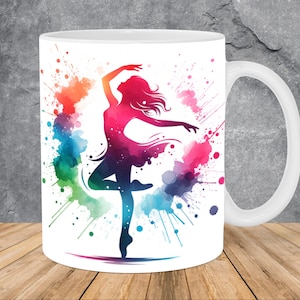 May include: White ceramic mug with a colorful watercolor design of a dancer in a silhouette. The dancer is in a pose with one leg extended and the other leg bent at the knee. The watercolor design is in shades of pink, blue, green, and yellow.