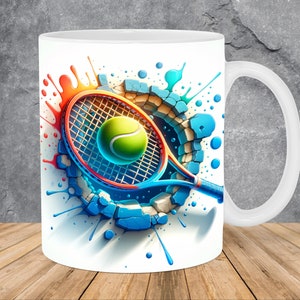 May include: White ceramic mug featuring a tennis theme. The design includes a tennis racket, a tennis ball, and a broken wall effect with blue, orange, and white accents. The mug has a white handle and a glossy finish.