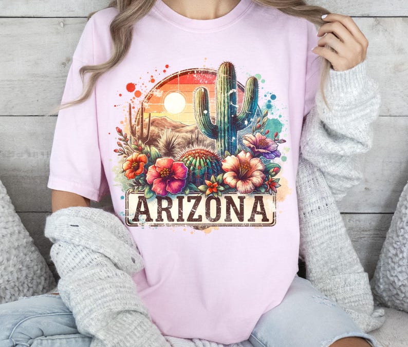 May include: Pink t-shirt featuring a watercolour design of a cactus, flowers, and the text "ARIZONA".