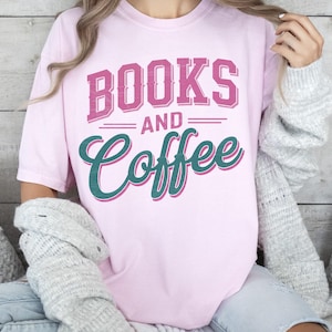 Pu&ograve; includere: T-shirt rosa chiaro con la scritta "BOOKS AND COFFEE" in rosa e verde acqua. La maglietta &egrave; in stile casual, adatta per l'uso quotidiano. Il testo &egrave; in un carattere leggibile.