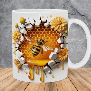 May include: White ceramic mug featuring a detailed illustration of a bee, honeycomb, and dripping honey. The design includes yellow flowers and a cracked wall effect, creating a 3D appearance. The mug has a white handle and is set against a wooden surface.