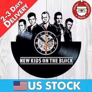 May include: Black vinyl record clock featuring a silhouette of the band New Kids on the Block. The clock has a silver face with black numbers and hands. The clock is mounted on a black background.