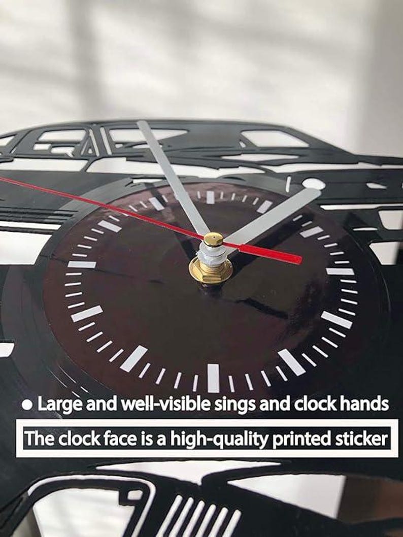 K&ouml;nnte beinhalten: Schwarze Wanduhr mit einem Auto-Silhouette-Design. Die Uhr hat ein dunkles Zifferblatt mit wei&szlig;en Markierungen und silbernen Zeigern, mit einem roten Sekundenzeiger. Der Text auf der Uhr lautet: "Large and well-visible sings and clock hands. The clock face is a high-quality printed sticker."