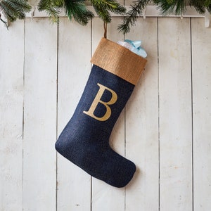Puede incluir: Una media de Navidad azul y dorada con la letra "B" en la parte delantera.