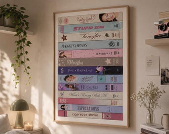 May include: A framed wall art print featuring a vertical stack of colorful VHS tape spines. The labels display various titles including Stupid Song, Honeybee, Maggots in Brains, u + me = <3, My Way, Purple, the love, Begged, What's Wrong With Me, Expectations, and cigarette smoke.