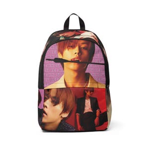 May include: A black backpack with a pink and red design featuring a collage of images of three men. The text "Lee Know" is repeated in pink on the backpack.