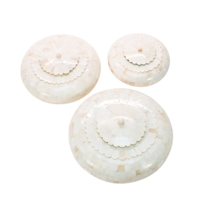 Puede incluir: Tres cajas redondas decorativas blancas con intrincados diseños florales. Las cajas están hechas de nácar y tienen un aspecto delicado y elegante.