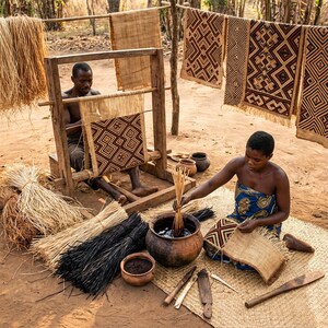 May include: Artisans weaving intricate geometric patterns on woven mats and textiles. The image shows the process of creating traditional crafts, with materials like straw and natural dyes. Finished pieces hang to dry, showcasing the detailed craftsmanship.