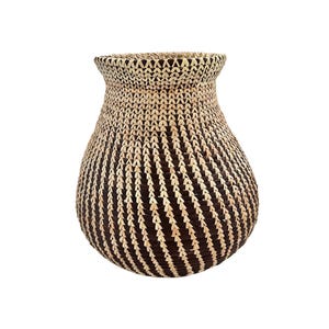 May include: A woven basket with a bulbous shape and a wide opening. The basket is made of natural-colored and dark brown materials, creating a striped pattern. The design features a textured surface and a decorative appeal.