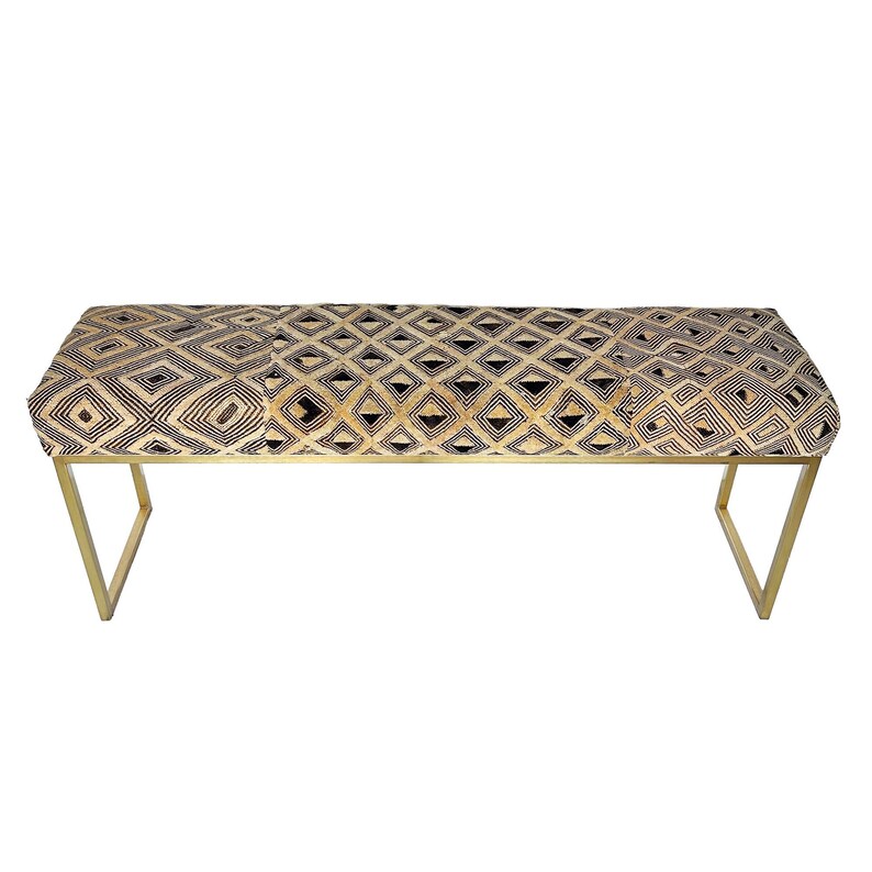 May include: A rectangular bench with a geometric pattern in black and tan. The bench has a gold metal frame and is approximately 60 inches long.