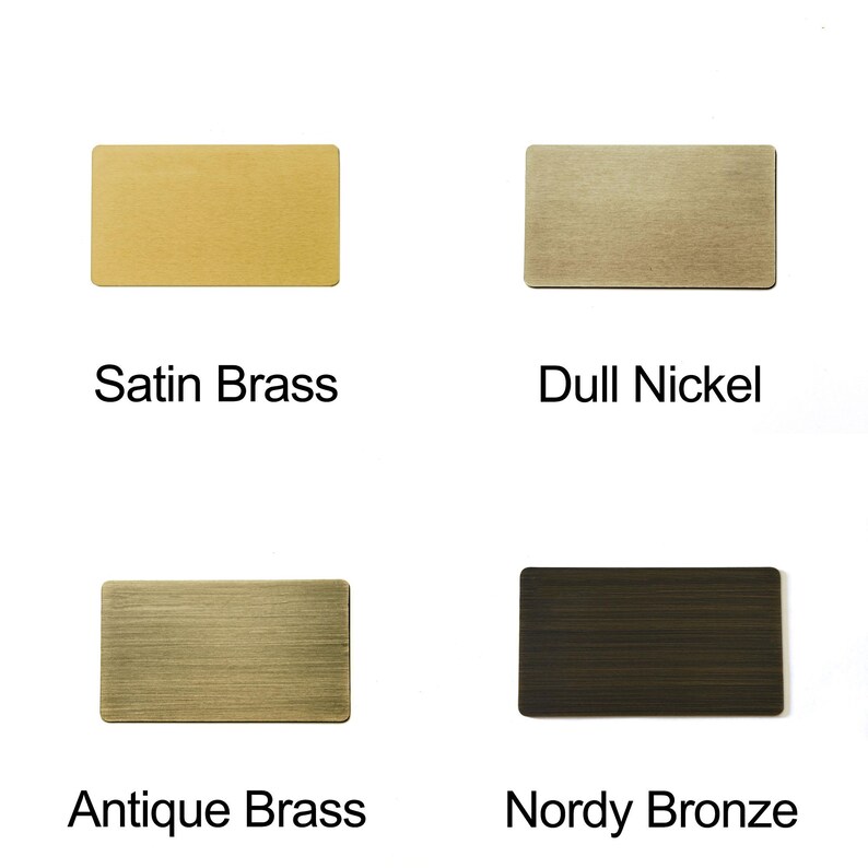May include: Four rectangular metal samples in different finishes: Satin Brass, Dull Nickel, Antique Brass, and Nordy Bronze. Each sample has a brushed texture and is labeled with its finish name in black text.