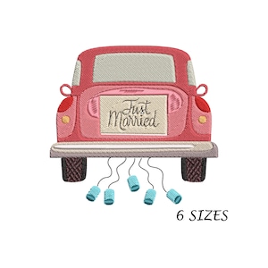 Pode incluir: Um carro rosa com uma placa de "Just Married" na traseira. O carro tem latas azuis amarradas ao para-choques traseiro com corda.