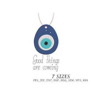 Puede incluir: Un colgante bordado azul con un diseño de ojo, con un centro blanco y turquesa, y una cuerda marrón. El texto "Good things are coming" está debajo del colgante. La imagen también incluye el texto "7 SIZES".