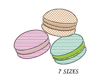 May include: Three embroidered macarons in different colors: pink, brown, and green. Each macaron has a white filling. The text "7 SIZES" is below the macarons.