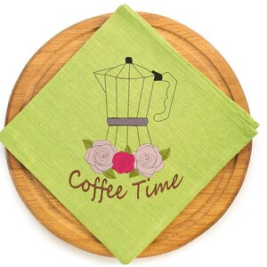 May include: A lime green square napkin with a coffee pot illustration and the words "Coffee Time" in brown script. The napkin is on a round wooden serving board. The coffee pot is black and gray with pink and red roses.