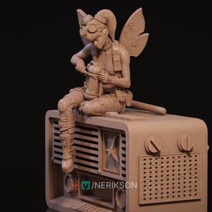 Könnte beinhalten: Detaillierte Skulptur einer feenartigen Figur in Steampunk-Kleidung, die auf einem Vintage-Radio sitzt. Die Figur trägt eine Brille, einen Gurt und Knieschützer und hält eine Laterne. Das Radio hat Knöpfe und einen Lautsprechergrill.