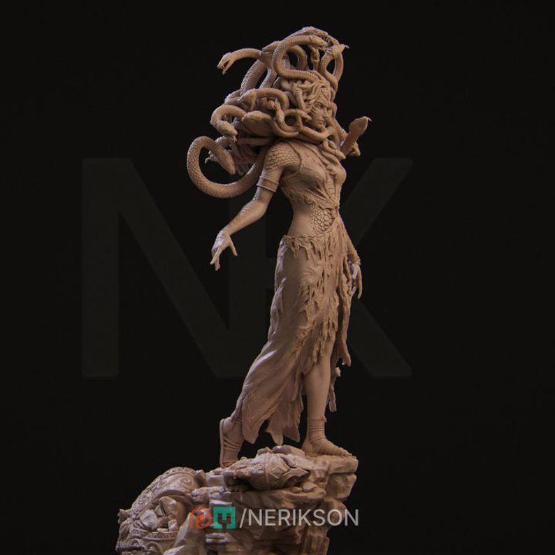 May include: A detailed clay sculpture of Medusa, a mythical Greek figure with snakes for hair, standing on a rocky base. She is depicted with a fierce expression and a flowing gown.