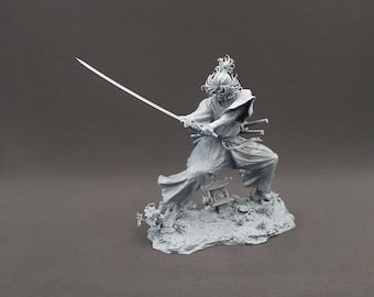 Può includere: Statuetta grigia di un samurai in posa dinamica, che brandisce una katana. La figura indossa abiti tradizionali e si trova su una base dettagliata con piante in miniatura e una lanterna. I capelli del samurai sono raccolti in uno chignon.