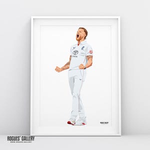 Op de afbeelding: Een ingelijste illustratie van een cricketspeler in een wit uniform, die juicht met opgeheven armen. Het Toyota-logo is zichtbaar op het shirt. Het kunstwerk staat tegen een witte achtergrond.