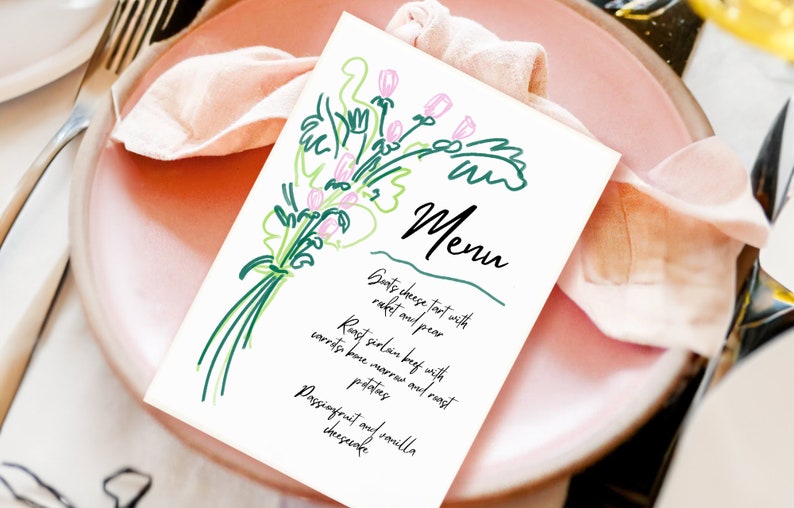 May include: A white menu card with a green and pink floral illustration. The menu lists: Goats cheese tart with rocket and pear, Roast sirloin beef with carrots bone marrow and roast potatoes, Passionfruit and vanilla cheesecake.