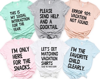 May include: Six short-sleeved t-shirts in various pastel colors, each with a humorous phrase in black block letters. The shirts include phrases like "This is my social interaction for the year" and "I'm only here for the snacks."