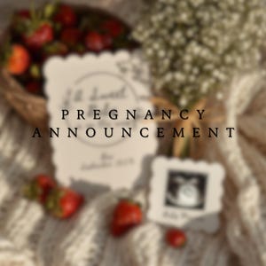 May include: A pregnancy announcement card with the words "Pregnancy Announcement" in black text. The card is surrounded by strawberries, flowers, and a small ultrasound photo. The overall aesthetic is soft and romantic.