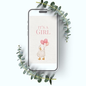 May include: A smartphone displays a baby shower invitation with the text "IT'S A GIRL." The invitation features a watercolor illustration of a white duck holding pink balloons. Eucalyptus sprigs frame the phone.