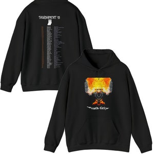 Op de afbeelding: Zwart hoodie met een afbeelding van een brandende schedel en de tekst "Death Grips" op de voorkant. De achterkant van de hoodie heeft een lijst met tourdata met de tekst "Tournament '93".