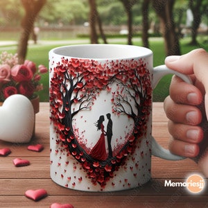 Puede incluir: Taza de cer&aacute;mica blanca con un dise&ntilde;o en forma de coraz&oacute;n rojo que presenta una pareja de pie bajo un &aacute;rbol con hojas rojas. La taza tiene un asa negra.