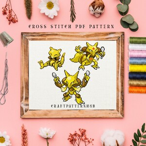 Könnte beinhalten: Kreuzstichmuster mit drei gelben Pokémon-Charakteren, darunter ein Raichu mit einem Mikrofon, ein Pikachu mit einem Mikrofon und ein Pichu mit einem Löffel. Das Muster ist in einem Holzrahmen gerahmt und der Text "CRAFTPATTERNHUB" befindet sich am unteren Rand des Musters.