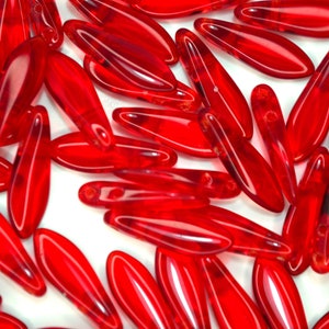 May include: A group of red glass beads in a teardrop shape. The beads are translucent and have a glossy finish.