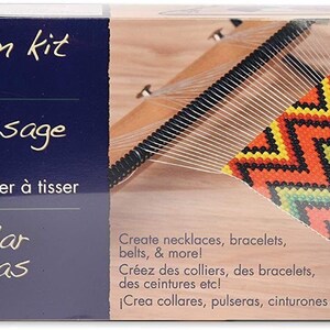 Può includere: Un kit telaio per perline Bead Smith con un telaio grande. La scatola presenta testo in inglese, francese e spagnolo. L'immagine mostra un progetto di perline colorate parzialmente completato con un motivo a zig-zag. Il kit è progettato per creare collane, bracciali e cinture.