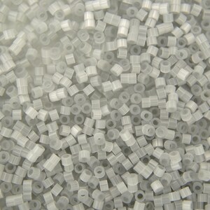 May include: A large quantity of small, white, plastic beads. The beads are cylindrical with a hole through the centre.