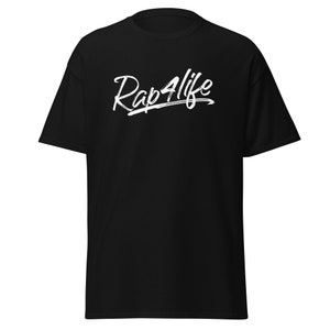 Può includere: T-shirt nero con la scritta bianca "Rap4life" in stile scritto a mano. La maglietta ha maniche corte e girocollo. Il tessuto sembra morbido e confortevole.