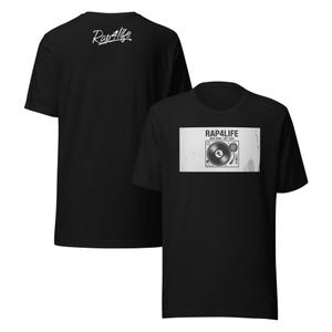 May include: Black t-shirt featuring a turntable graphic with the text "RAP4LIFE NEW YORK EST. 2024". The back of the shirt has the text "Rap4life" in a cursive font.