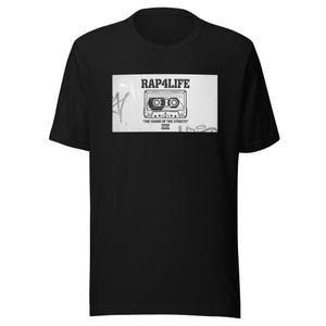 Può includere: T-shirt nera con grafica in bianco e nero di una musicassetta. Il testo "RAP4LIFE" e "THE SOUND OF THE STREETS" sono visualizzati sopra e sotto l'illustrazione della cassetta.
