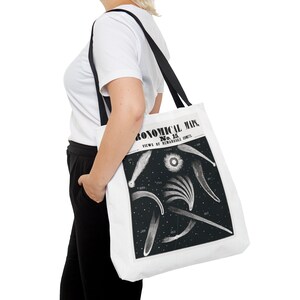 May include: White tote bag with black straps featuring a vintage illustration of comets. The illustration is titled "Astronomical Map No. 15. Views of Remarkable Comets."
