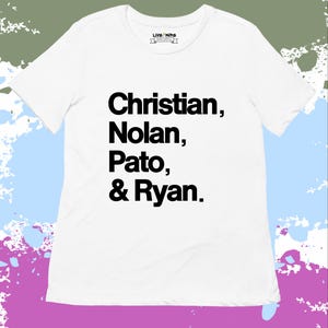 Op de afbeelding: Wit T-shirt met de namen "Christian, Nolan, Pato, & Ryan" in vette zwarte letters. Het shirt heeft een ronde hals en korte mouwen. Het merklogo "LIVE NIRS" staat in het midden bovenaan.